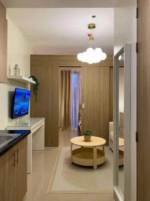a kitchen with a table and a living room at Crystal Cove by Casa Stellar Mall of Asia Complex in Manila