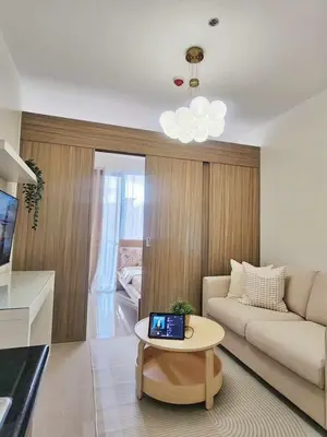 a living room with a couch and a table at Crystal Cove by Casa Stellar Mall of Asia Complex in Manila