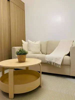 a living room with a couch and a table at Crystal Cove by Casa Stellar Mall of Asia Complex in Manila