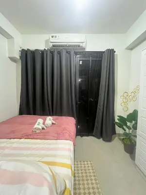 a bedroom with a bed with shoes on it at Shore 2 Residences by Casa Stellar mall of Asia Complex in Manila