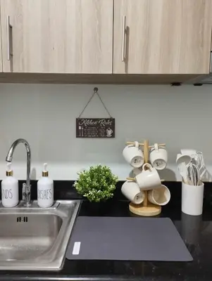 a kitchen counter with a sink and cups and a sink at Shore 2 Residences by Casa Stellar mall of Asia Complex in Manila