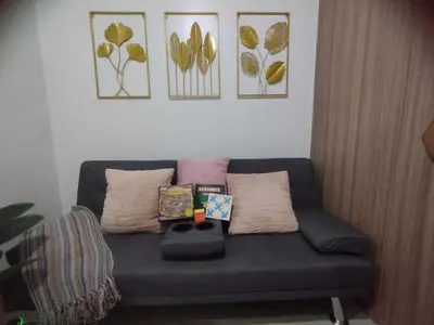 a blue couch in a living room with pillows at Shore 2 Residences by Casa Stellar mall of Asia Complex in Manila