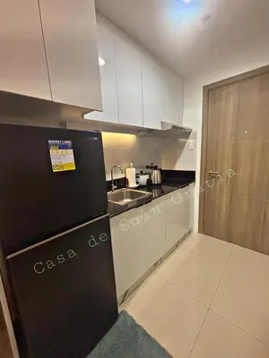 a small kitchen with a sink and a refrigerator at Casa De Sola Gratia in Manila