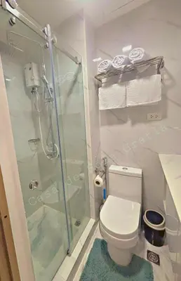 a bathroom with a toilet and a glass shower at Casa De Sola Gratia in Manila