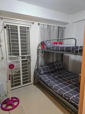 a bedroom with two bunk beds and a fan at Homey Airport bnb 1BR w Wi-Fi in Manila