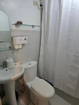 a bathroom with a white toilet and a sink at Homey Airport bnb 1BR w Wi-Fi in Manila