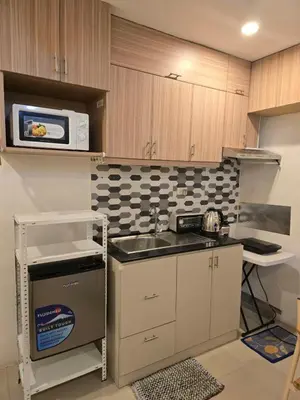 a small kitchen with a sink and a microwave at Homey Airport bnb 1BR w Wi-Fi in Manila