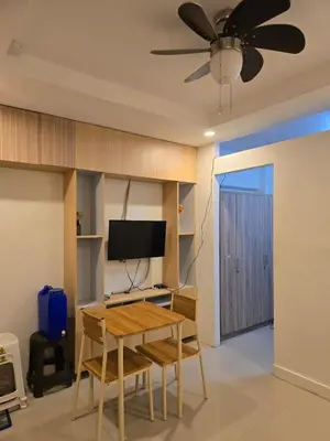 a living room with a table and a ceiling fan at Homey Airport bnb 1BR w Wi-Fi in Manila