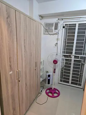 a pink fan sitting on the floor next to a cabinet at Homey Airport bnb 1BR w Wi-Fi in Manila