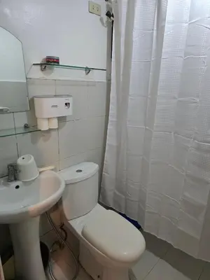a bathroom with a white toilet and a sink at Homey Airport bnb 1BR w Wi-Fi in Manila