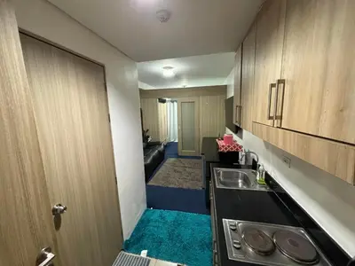 a small kitchen with a sink and a door at MOA Home Away From Home in Manila