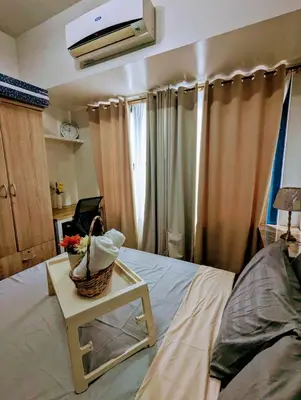 a bedroom with a bed and a table with a basket of flowers at Oak and Slate Oasis in Manila