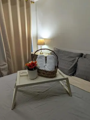 a basket on a table with a lamp on a bed at Oak and Slate Oasis in Manila