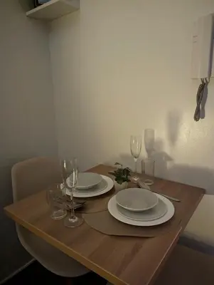 a wooden table with plates and wine glasses on it at Oak and Slate Oasis in Manila