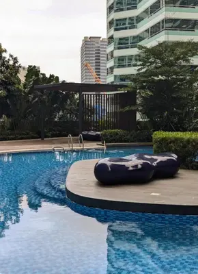 a swimming pool with an inflatable raft in front of a building at Oak and Slate Oasis in Manila