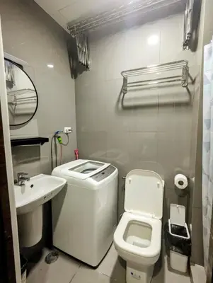 a small bathroom with a toilet and a sink at Oak and Slate Oasis in Manila