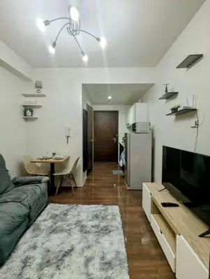 a living room with a couch and a television and a table at Oak and Slate Oasis in Manila