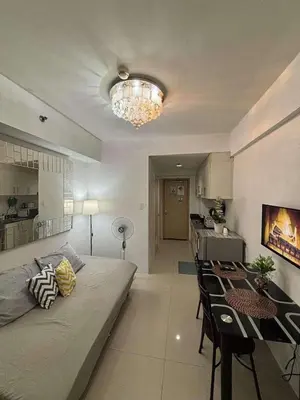 a living room and kitchen with a bed and a table at Casa Amara Staycation in Manila