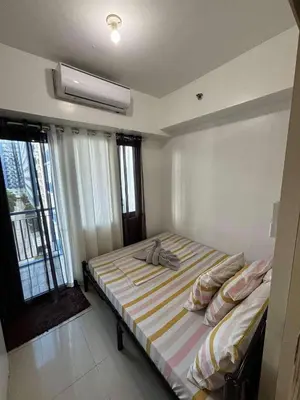 a bedroom with a bed in a room with windows at Casa Amara Staycation in Manila