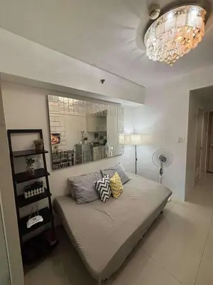 a bedroom with a bed and a chandelier at Casa Amara Staycation in Manila