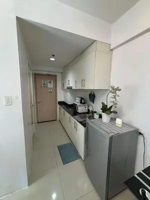 a small kitchen with white cabinets and a counter top at Casa Amara Staycation in Manila