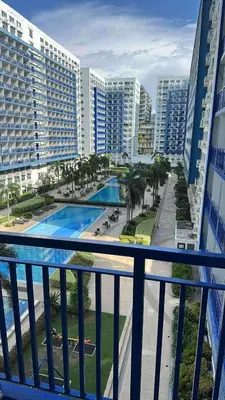 a balcony with a view of a pool and buildings at Casa Amara Staycation in Manila