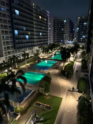 an overhead view of a pool in a city at night at Casa Amara Staycation in Manila