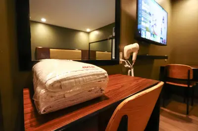 a room with a bed on a table with a television at Hotel Sogo Dasmariñas Cavite in Dasmariñas