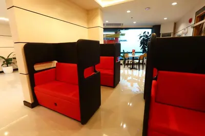a living room with two red chairs and a table at Hotel Sogo Dasmariñas Cavite in Dasmariñas