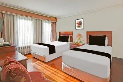 a hotel room with two beds and a couch at Collection O VIP Suites, Near PNR Pasay Evangelista, Makati Manila in Manila