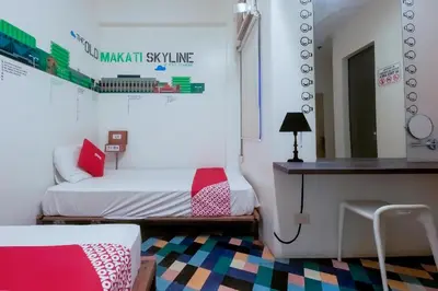 a room with two beds and a desk in it at Junction Hostel, Poblacion Makati Avenue, Manila in Manila