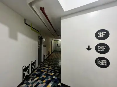 a hallway with signs on the wall of a building at Junction Hostel, Poblacion Makati Avenue, Manila in Manila