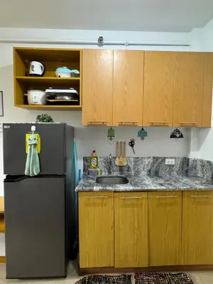 a kitchen with a sink and a refrigerator at Minimalist Studio Condo - Alabang Near Airport in Manila