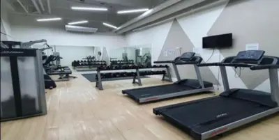 a gym with treadmills and ellipticals in a room at Minimalist Studio Condo - Alabang Near Airport in Manila
