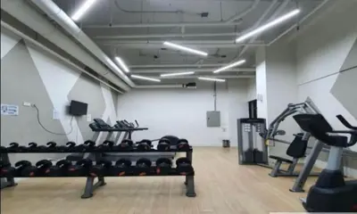a gym with rows of racks of exercise equipment at Minimalist Studio Condo - Alabang Near Airport in Manila