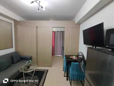 a living room with a couch and a television at G Spot Manila - Mall of Asia in Manila