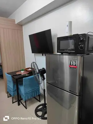 a kitchen with a microwave on top of a refrigerator at G Spot Manila - Mall of Asia in Manila
