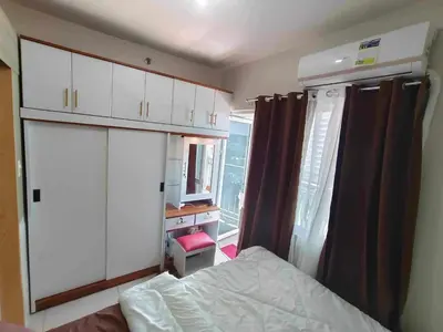 a bedroom with a bed and a desk and a window at Condo in Pasay in Manila