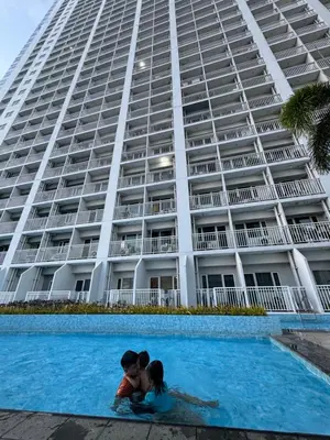 a couple kissing in the swimming pool in front of a building at Condo in Pasay in Manila