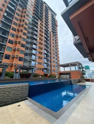 a swimming pool in front of a large building at Porto Vita 2BR in Manila