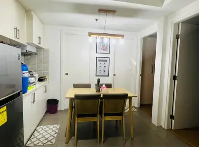 a kitchen with a table and chairs in a room at Porto Vita 2BR in Manila