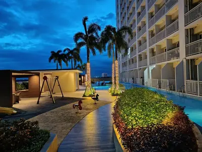 a view of a hotel with a playground and palm trees at Affordable staycation in Pasay-Breeze Residence in Manila