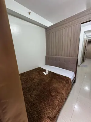 a bedroom with a large bed with a brown blanket at Mall of Asia Staycation by Mochi - SMDC Shore 2 Tower 3 in Manila