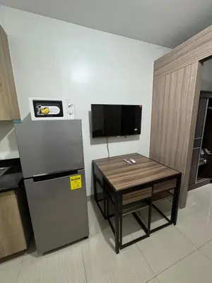 a small kitchen with a table and a refrigerator at Mall of Asia Staycation by Mochi - SMDC Shore 2 Tower 3 in Manila