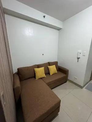 a couch with two yellow pillows in a room at Mall of Asia Staycation by Mochi - SMDC Shore 2 Tower 3 in Manila