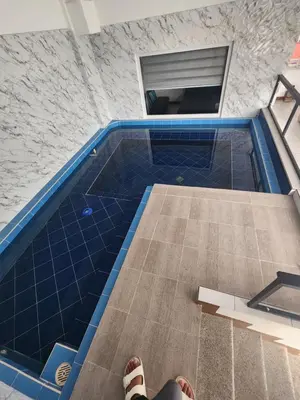 a person standing in front of a swimming pool at Solace View Rooftop in Manila