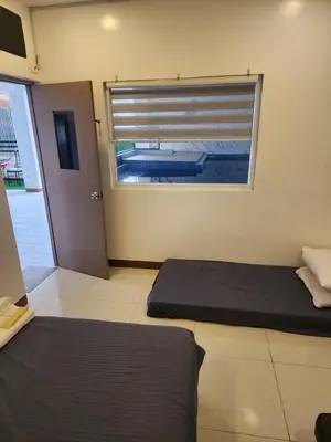 a room with two beds and a window with a pool at Solace View Rooftop in Manila