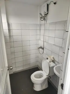 a small bathroom with a toilet and a sink at Solace View Rooftop in Manila