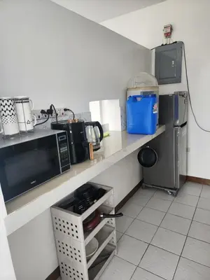 a kitchen with a counter with a sink and a microwave at Solace View Rooftop in Manila