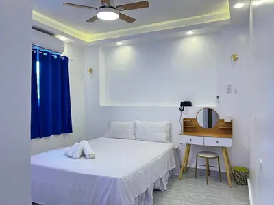 a bedroom with a bed and a desk with a ceiling fan at Shiri Pool Villa 1 in Silang